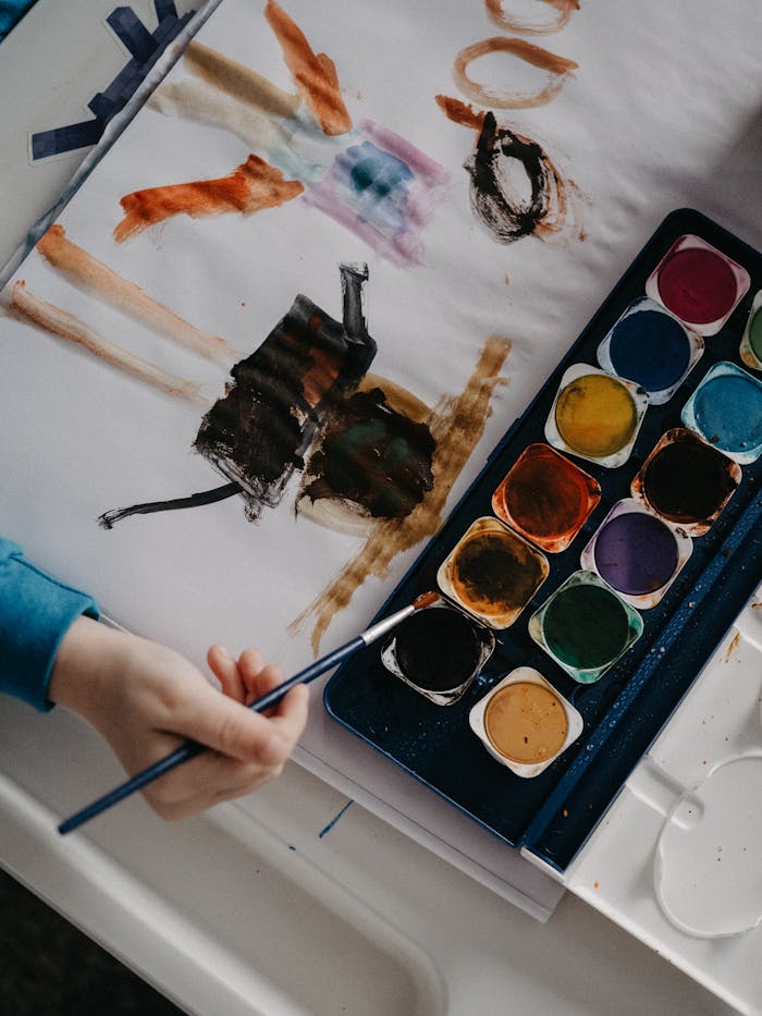 Mastering the First Impression: Your intriguing post title goes here A child paints abstract art using vibrant watercolors at a table.