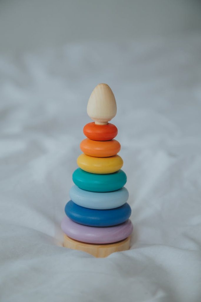 A colorful wooden stacking toy on a soft white background, perfect for child development.